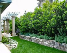 a stone wall in the middle of a yard