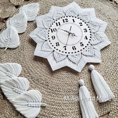 a white clock with tassels around it on top of a straw hat covered table