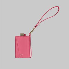 a pink card case with a lanyard and key chain hanging from the front, on a gray background