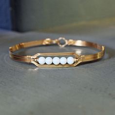 A contemporary little bracelet consisting of five strands of 14kt gold filled wire with a center design featuring five 4mm smooth glowing opalite beads and accented with two smaller 14kt gold filled beads. This sweet bracelet is stylish and simple, and it's stackable with most of my other wirewrapped bracelet styles! The opalite shifts from white to blue to lavender overtones, depending on what you wear it with, making it the perfect accessory for every outfit! The sturdy built-in hook and eye c Wire Beaded Bracelets, Wrapped Bracelets, Wire Jewerly, Bracelet Styles, Jewelry Aesthetic, Small Bracelets, Bracelet Bead, Wire Bangles, Wire Wrapped Bracelet