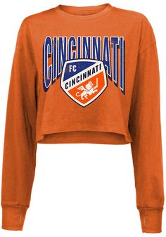 Display your FC Cincinnati spirit in this FC Cincinnati Orange T-Shirt! This FC Cincinnati Cropped Long Sleeve T-Shirt makes a great layer for cooler nights cheering on the FC Cincinnati. Featuring a screen print team name and logo on center chest, this FC Cincinnati Long Sleeve LS Tee is a must-have for any fan. WE don't, WE don't, WE don't mess around, HEY!! Long sleeve, Dropped shoulder, Raw hem, Ridged cuffs on sleeves, Soft hand, 100% Cotton, 4 Fall Sports Team Logo Tops, Fall Sports Event Tops With Team Logo, Team-colored Tops For Sports Events In Fall, Fan Apparel Top With Team Logo For Fall, Fan Apparel Tops With Team Logo For Fall, Fall Fan Apparel Top With Team Logo, Team Logo Tops For Fall Fan Gear, Team Logo Tops For Fan Gear In Fall, Fall Sports Fan Top With Team Logo