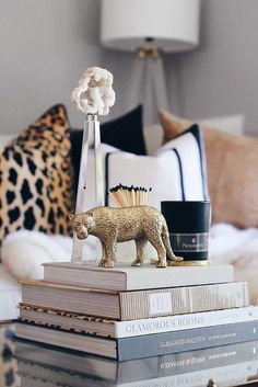 a stack of books sitting on top of each other in front of a table lamp