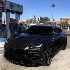 a black sports car parked at a gas station