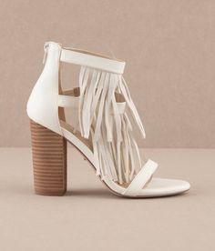 Get ready to party with these Take Me Out Cream Fringe Heels by Oasis Society. Designed with a vegan leather upper and dreamy DreamCloud Cushion insole, these quirky block heels are perfect for concerts or a night out. With a 4" shaft and 3.75" heel, you'll love everything about them - especially the cream color and playful fringe details! About this product Materials: * Upper Material: * White:Vegan leather upper * Khaki: Rough Suede Upper * Insole Material: DreamCloud Cushion * Sole or Heel Ma Razorback Shirt, Clear Stadium Bag, Fringe Heels, Wrap Heels, Take Me Out, Sneaker Jewelry, Capri Blue, Blue Gifts, The Cream