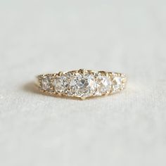 a three stone diamond ring sitting on top of a table