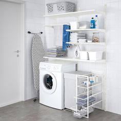 a washer and dryer in a room with white tile walls, flooring and shelving