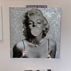 a black and white photo of a woman with a pacifier in her mouth hanging on the wall