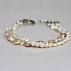 Two strands of delicate ivory freshwater pearls come together in a beachy bracelet.  Organic strands  go from soft white to rosy.  Fastened with a sturdy sterling silver toggle clasp for easy managing.  7.5" including clasp. Beachy Bracelets, Ithaca Ny, Double Ring, Toggle Clasp, Soft White, Pearl Bracelet, Freshwater Pearls, Beauty Book, Jewelry Bracelets