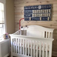 a white crib in a room with wood paneling on the wall behind it