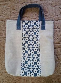 a white and blue tote bag sitting on top of a carpet next to a wall