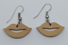 the earrings are made out of wood and have an image of a woman's mouth