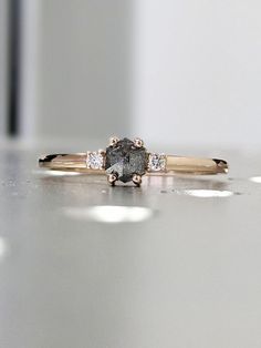 a diamond ring sitting on top of a white counter next to a wall with light coming through it