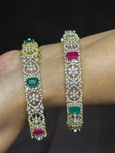 18 karat gold diamond kada with color stones - single piece 
  this product has 6 interchangeable red & green color stones in the bangle 
    note : this item comes with a clip. so that you can open it and wear it directly on your wrist. 
  this is a single piece   

introducing our exquisite 18 karat gold diamond kada with color stones - a true masterpiece of indian craftsmanship. this stunning bangle is a single piece that exudes elegance and sophistication. 
  
  featuring 6 inter Elegant Multi-stone Diamond Bangle, Luxury Multi-stone Women's Bangle, Luxury Multi-stone Bangle For Gift, Gold Bangle With Cubic Zirconia Stone Work, Elegant Ruby Bangle With Stone Work, Diamond Kada, Arm Jewelry, South Indian Jewelry, Color Stones