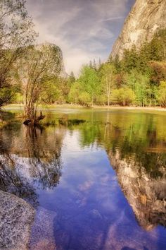 a lake surrounded by mountains and trees in the middle of it's own area