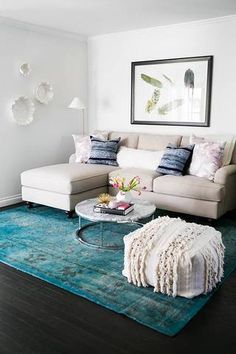 a living room filled with furniture and a rug on top of a hard wood floor