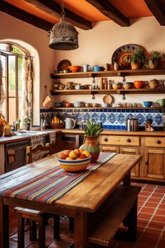 an old fashioned kitchen with oranges on the table and potted plant in the center