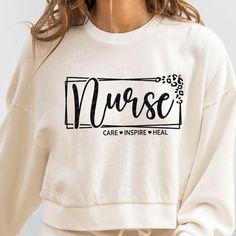 a woman wearing a white sweatshirt with the word nurse on it