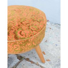 an orange and yellow ottoman sitting on top of cement