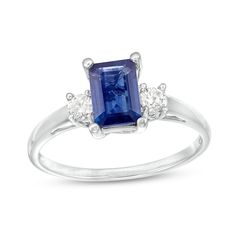 a blue sapphire and diamond ring with three diamonds on the band, set in white gold