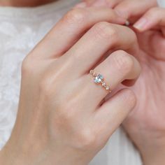 a woman's hand holding an engagement ring with two diamonds on it and the other hand