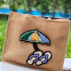 a small purse with an umbrella embroidered on it