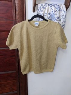 Vintage 70's metallic gold short sleeve baby tee sweater  The sweetest. So sophisticated!  Metallic gold threading throughout Vintage size small (petite)  But please see approximate measurements. Will fit a women's small nicely at a cute semi cropped length!  Ribbed knit banded on sleeves and bottom hem    Hanging photo is the most true to color, true gold, not green or yellow.  Bedford Fair  Retro and so classic at the same time Sparkle Purse, Pull Bebe, Semi Cropped, Gold Shorts, Hanging Photos, Pullover Sweater Women, Baby Tee, Women Pullover, Metallic Gold