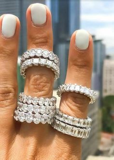 a woman's hand with three different rings on her fingers and one ring in the middle