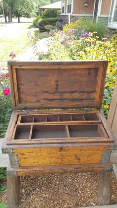 an old wooden chest sitting in the middle of a garden