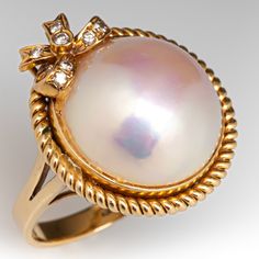 an image of a ring with pearls on it's sides and diamonds in the middle