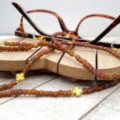 "Bohemian and dainty eye glasses necklace in golden tones with a hint of many colors, made with matte crystal Czech seed beads ( about 0.14\" - 3.5 mm ) and gold plated charms.  Paired with delicate gold plated crystal seed beads, this handmade eyeglass chain will definitely create a unique look. This eyeglass lanyard is made on strong quality beading wire with gold plated wire guardians that protect the quality white eyeglass holder grips. The necklace is ended with spring clasps that hold the Glasses Necklace, Sunglasses Necklace, Eyeglass Necklace, Sunglasses Chain, Mask Holder, Gold Elephant, Blue Glasses, Sunglass Chain, Mother Of Pearl Necklace