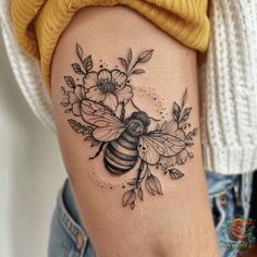 a woman's thigh with a bee and flowers on it