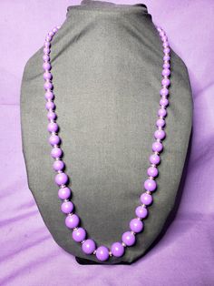 This is a very pretty vintage purple beaded necklace. The beads are in graduating sizes with the bigger ones in the front. They have light gold tone spacer disc beads between every purple bead. The spring ring closure is gold tone. It measures approximately 30 inches in total length. It is pre-owned and may have minor wear, but still looks to be in great condition. Lavender Single Strand Round Bead Jewelry, Adjustable Single Strand Lavender Beaded Necklace, Lavender Single Strand Jewelry With Round Beads, Adjustable Lavender Single Strand Beaded Necklace, Purple Beaded Necklaces With Large Round Beads, Purple Single Strand Beads For Gift, Single Strand Purple Beads For Gift, Purple Single Strand Beads As A Gift, Purple Necklaces With Colorful Round Beads