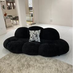 a large black couch sitting on top of a white floor