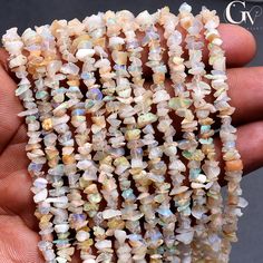 a hand is holding some white opalite beads