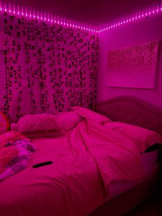 a bed with pink lights in a room