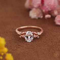 a close up of a ring on a brown surface with flowers in the back ground