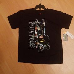 a batman t - shirt hanging on a wooden floor