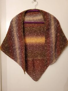 Knit shawl in various earth tones, including gold, brown, olive green, rust. Yarn is 58% cotton, 39% acrylic, and 3% "other" About 52" x 29"  Made in a smoke-free, cat-friendly home. While I try my best, Ms. VonPoof likes to send some love (in the shape of a few long white hairs) with each package. Brown Knitted Shawl For Fall, Brown Knitted One-size Shawl, Brown Shawl Wrap For Fall, Fall Brown Shawl Wrap, Brown Shawl Wrap One Size, Brown One Size Shawl Wrap, Brown One-size Shawl Wrap, Knitted Brown Scarf For Fall, One Size Brown Knitted Scarves