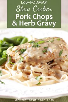 pork chops and herb gravy on a white plate with green beans in the background