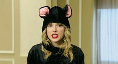 a woman wearing a black cat hat with ears on it's head and red lipstick