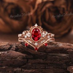 a close up of a ring with a red stone in the middle and white diamonds around it