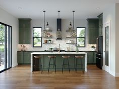 a kitchen with green cabinets and wooden floors