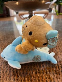 a teddy bear sitting on top of a blue dolphin