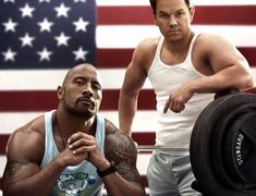 an image of two men in front of the american flag, one holding a barbell