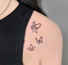 three butterflies tattoo on the back of a woman's left shoulder and upper arm