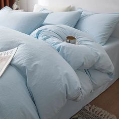 a bed with blue sheets and pillows on it