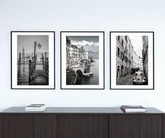 three black and white pictures hanging on the wall above a dresser in a living room