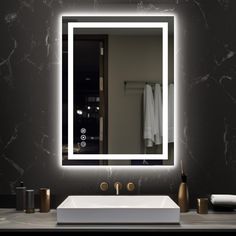 a bathroom sink with a lighted mirror above it