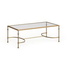 a coffee table with glass top and gold metal frame, sitting on a white background