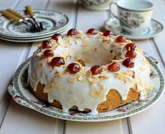 a bundt cake sitting on top of a table next to cups and saucers